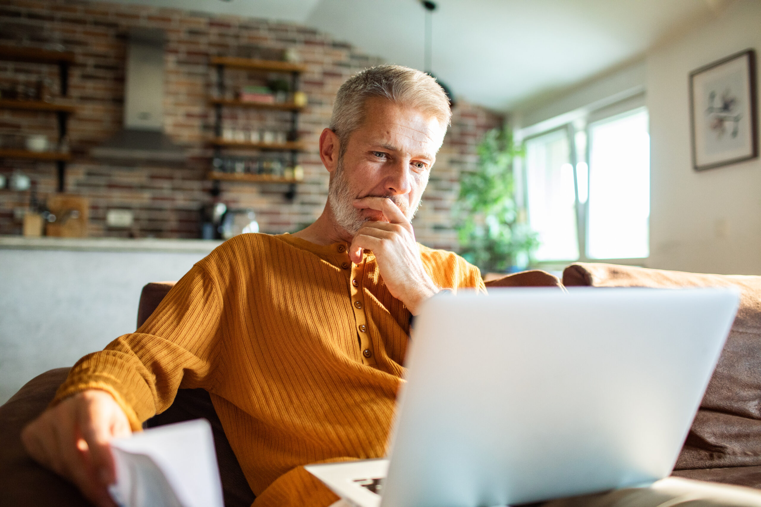 Mature man working on laptop at home