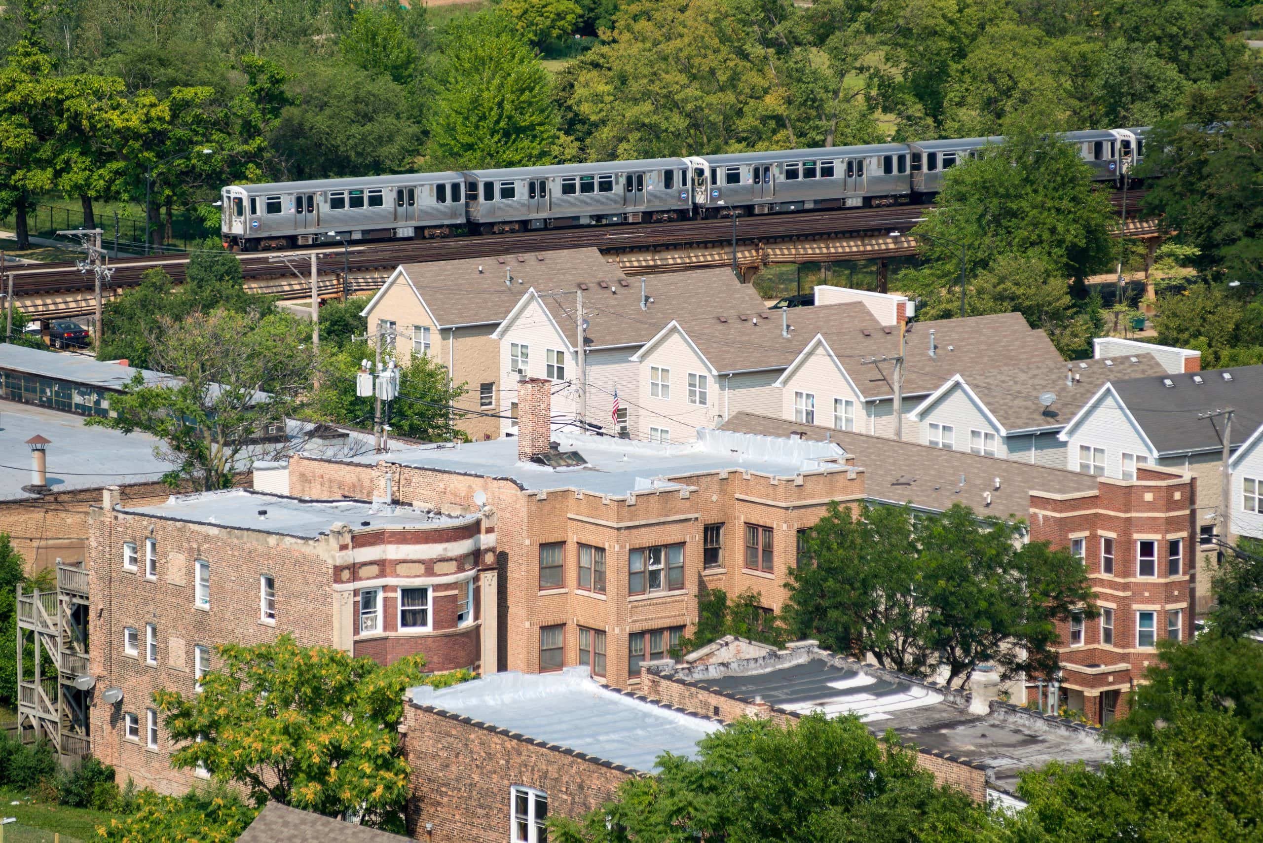 Chicago Transit Authority Green Line elevated train and tracks passes by neighborhood homes and housing