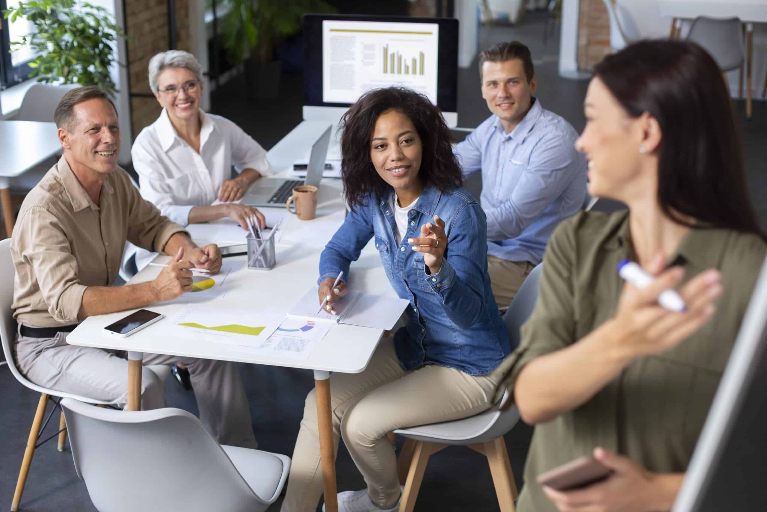 Female group of entrepreneurs discussing small business tips in a modern office setting.