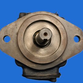 Close-up of a rusty metal bearing housing against a blue background, showing concentric rings and a central shaft area.