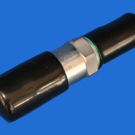 Close-up of a black cylindrical tube with a silver hex nut and green gasket against a blue background.