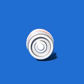 Close-up of stacked metal washers forming a spiral near the bottom center against a solid blue background