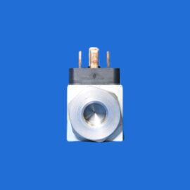 Close-up of an electrical component with three copper terminals on a black top and a silver circular dial on a white base against a blue background.