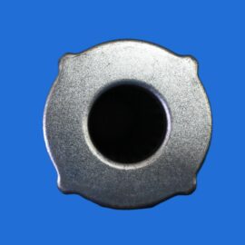 Close-up of a silver metal ring with a dark inner hole against a solid blue background, macro shot emphasizing texture and edges.