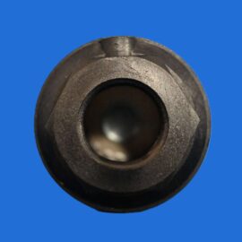 Close-up of a dark metal cylindrical bearing/bushing with an inner bore, set against a solid blue background.