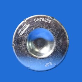 Close-up of a worn metal dial with 'SH7522' engraved, set against a solid blue background.