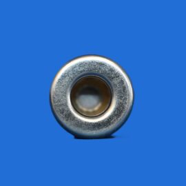 Close-up of a metallic circular washer with a hollow center on a solid blue background.