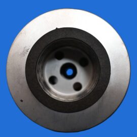 Macro image of a metal circular socket with a black gasket and four inner holes against a blue background.