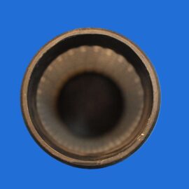Close-up of a metal pipe opening viewed from the end against a blue background.