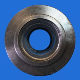 Close-up of a metal bearing or washer with concentric rings on a blue background.