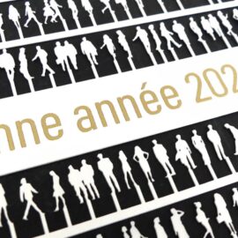 Bonne année 2026 écrit en doré sur un papier découpé en forme de personnage de maquette