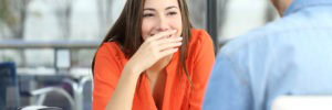 woman covering teeth