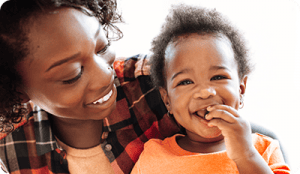 Mom with toddler smiling and eating