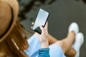 mujer con tel&eacute;fono whatsapp business geandce