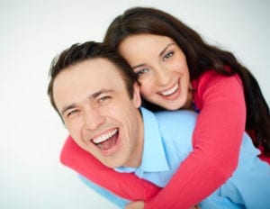 Portrait of amorous young woman embracing her happy husband