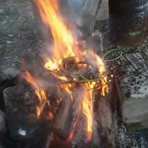In clip from YouTube video, an unknown scrap collector burns plastic shielding off extension cords.