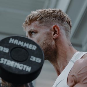 a man holding a barbell in his right hand