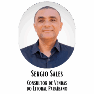 Retrato de um homem gentil, com cabelo curto, usando uma camisa azul escura, sorrindo levemente, em fundo branco, transmitindo simpatia e profissionalismo.
