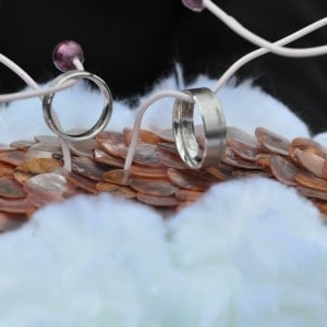 Floristisches Ringkissen aus Perlmutscheiben und wei&szlig;en Bommeln