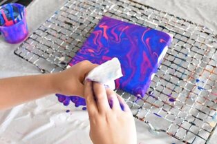 kid wiping paint off hands with baby wipes