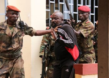 Members of the armed forces arrest Central African MP Alfred Yekatom aka "Rambo" (C), who represents the southern M'baiki district former militia leader, after he fired the gun at the parliament in Bangui on October 29, 2018. - A lawmaker fired into the air in the Central African Republic's parliament on October 29, 2018 after an altercation with a colleague as MPs prepared to vote for a new speaker. (Photo by Gael GRILHOT / AFP)        (Photo credit should read GAEL GRILHOT/AFP/Getty Images)