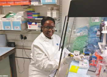 Dr. Kibirige takes a quick moment to smile for the camera while doing her very important work improving HIV assay tests. 