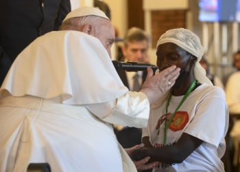 Pope Francis caresses the cheek of a woman whose hand was amputated in the violence that continues to plague the eastern part of Congo. The pope met victims of violence Feb. 1, 2023, at the apostolic nunciature in Kinshasa. (CNS photo/Vatican Media)