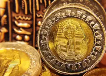 Golden Tut Change. Egyptian pound coins against a hieroglyphic background. Image for illustrative purposes only.