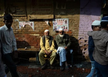 Muslim men sit along a road in a riot-affected area, in New Delhi on March 1, 2020, after violence broke out in India's capital. (AFP/File)