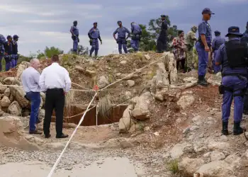 Police officers and private security personnel stand by the opening of a reformed gold mineshaft where illegal miners are trapped in Stilfontein, South Africa Frica Novermber 25, 2024 (AP Photo/Denis Farrell)