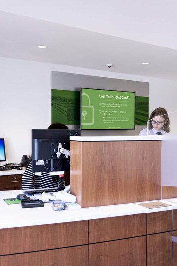 Digital displays convey relevant, local information behind a bank teller line