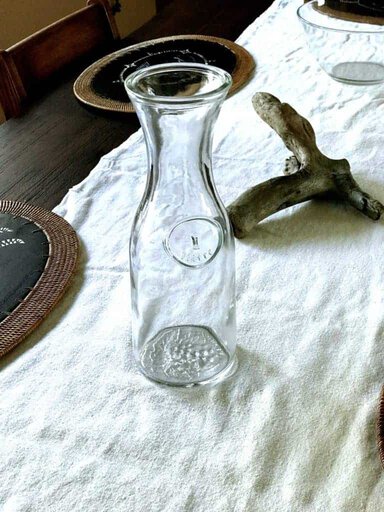 Dining table centerpiece of driftwood and clear water bottle