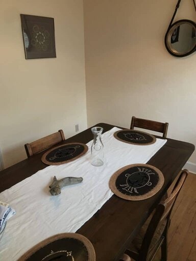 Brown dining table with white runner and rattan placemats- dining room ideas