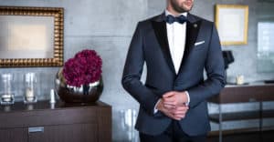 Man in expensive custom tailored tuxedo, suit posing indoors