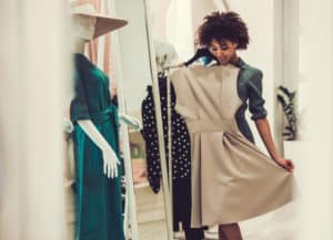 Woman picking out a tan dress