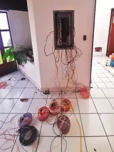 Electricista realizando trabajos de cableado eléctrico a domicilio en Lima