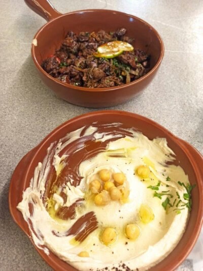 Humus sa susamom i posluženje pečenog mesa u glinenim posudama