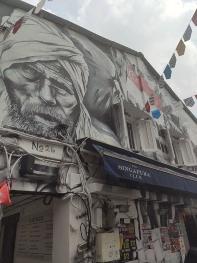 Crno beli mural muškarca sa turbanom iznad table sa natpisom kluba