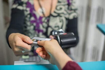 Woman handing another woman a credit card for a purchase