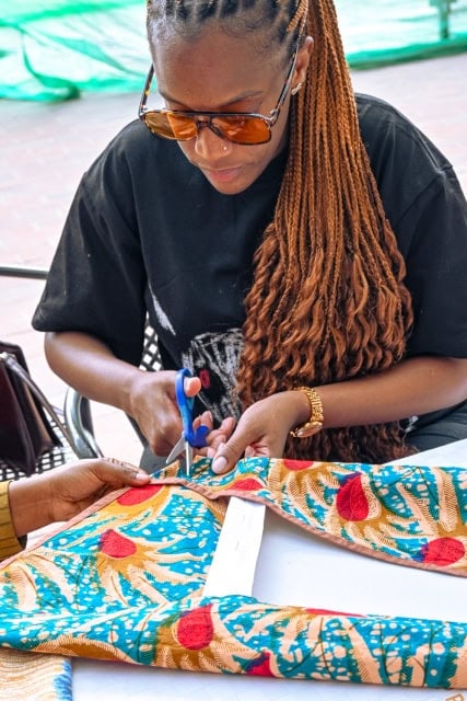 A workshop participant cuts colourful patterned fabric during the Frame and Fabric Workshop at Galleria.