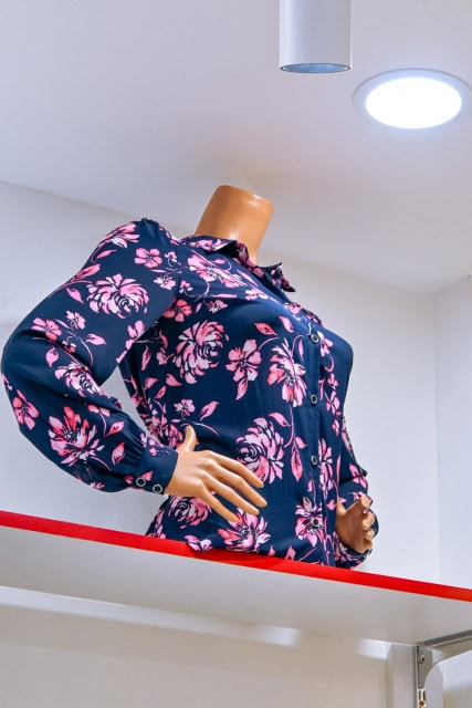 Headless mannequin wearing a navy jacket with a pink floral pattern