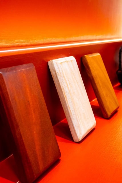 Rectangular wood finish samples arranged against a red illuminated display wall