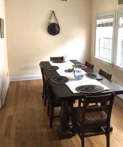 Dining room scene with large Tuscan style farmhouse table and placemats, runner