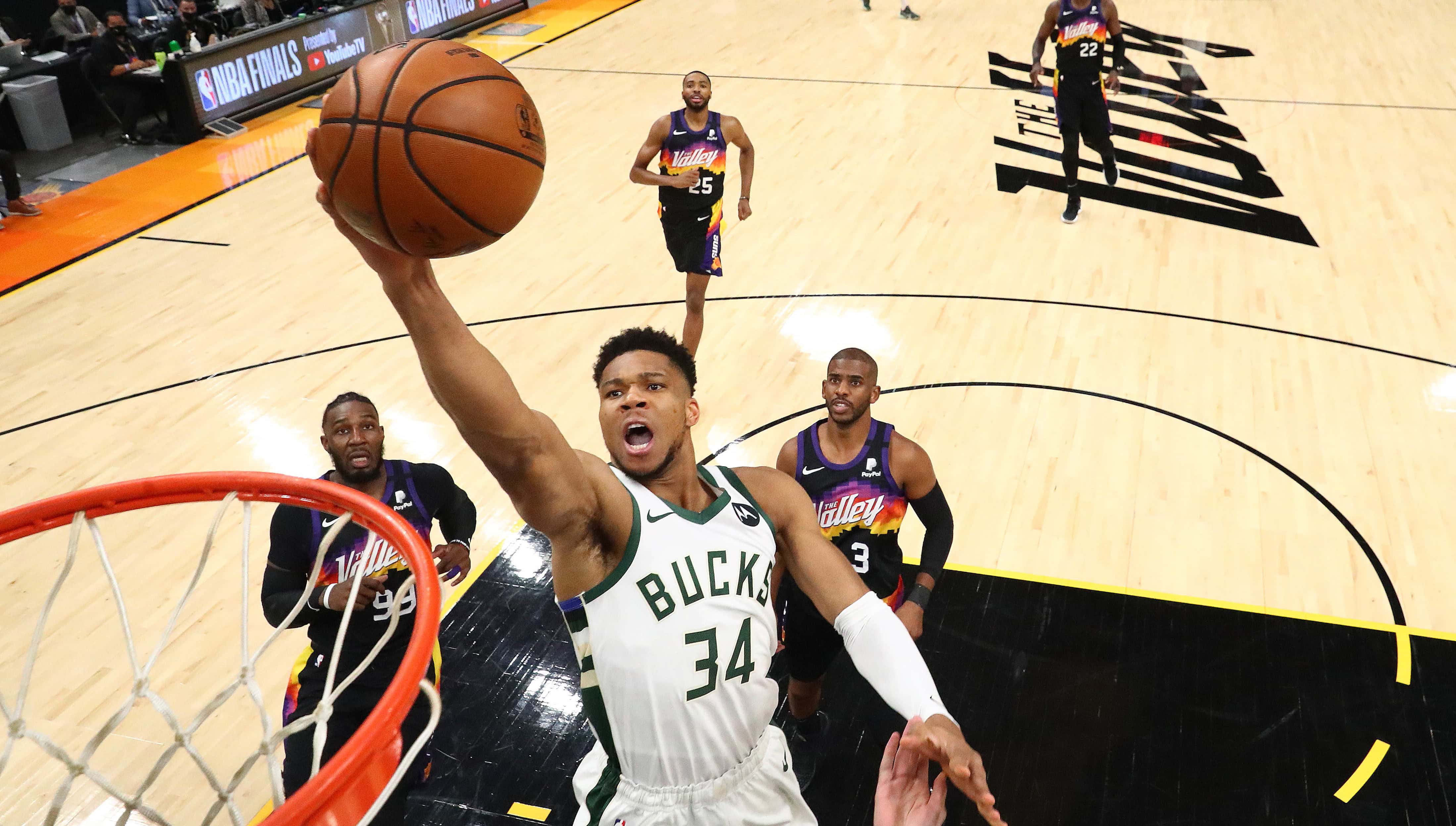 Basketball player Giannis Antetokounmpo jumping in the air to dunk a basketball during the 2021 NBA Finals