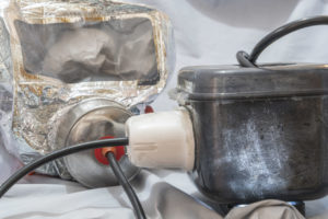 A gas mask with a tube running to a box with light inside