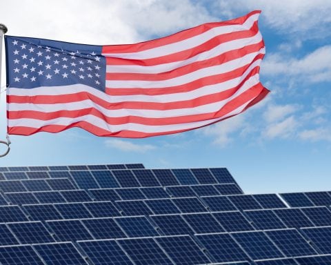 American flag flutters on the backgorund of solar panels. Symbol of sustainable development United States of America.