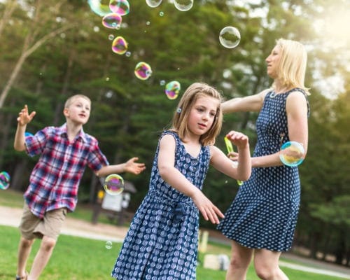 family photography spring Simsbury ct family of five red and blue color scheme playing with soap bubbles