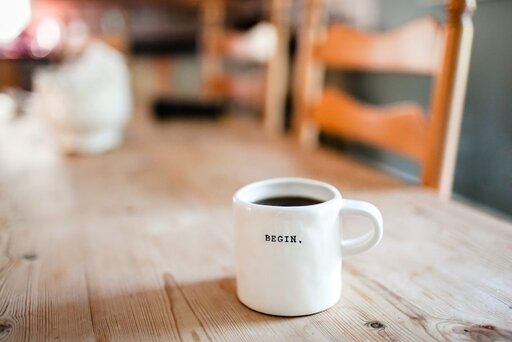 Blogging - Coffee cup on table stamped "BEGIN."