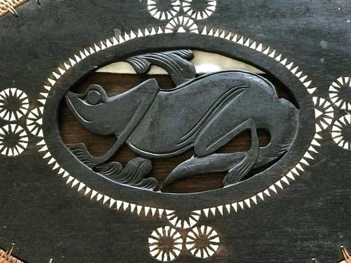 Center closeup of rattan placemat with lizard carved in wood and pearl inlay