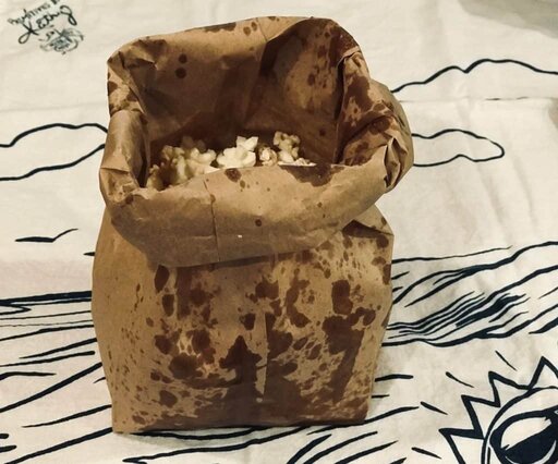 Paper Bag Popcorn finished product sitting up on towel with paper bag top folded over ready to serve